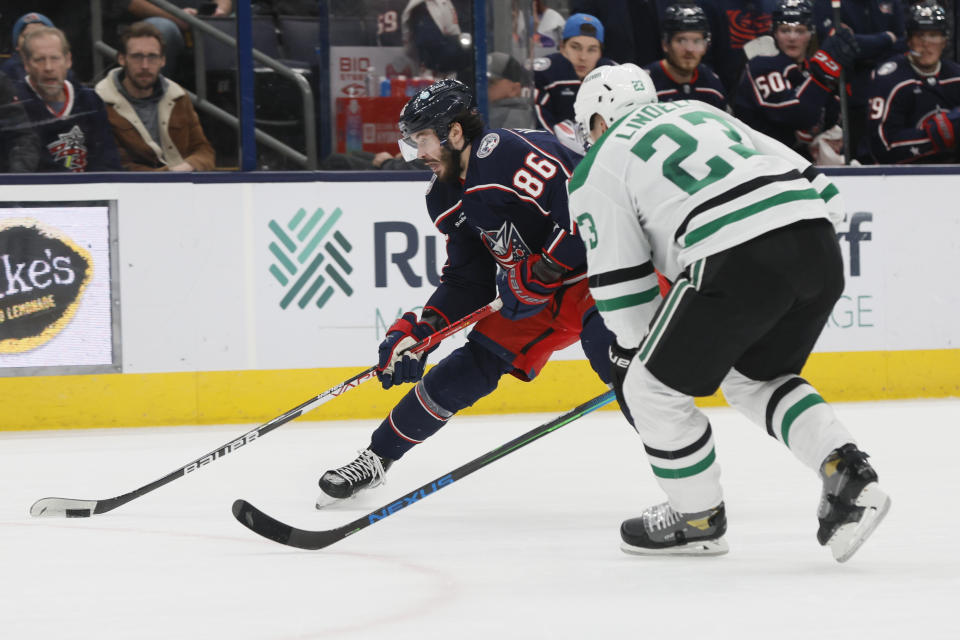 Columbus Blue Jackets' Kirill Marchenko, left, looks for an open shot as Dallas Stars' Esa Lindell defends during the second period of an NHL hockey game on Monday, Dec. 19, 2022, in Columbus, Ohio. (AP Photo/Jay LaPrete)