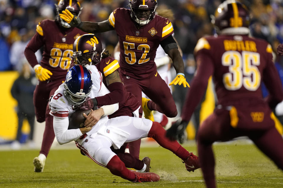 New York Giants quarterback Daniel Jones (8) is tackled by Washington Commanders safety Bobby McCain (20) during the second half of an NFL football game, Sunday, Dec. 18, 2022, in Landover, Md. (AP Photo/Patrick Semansky)