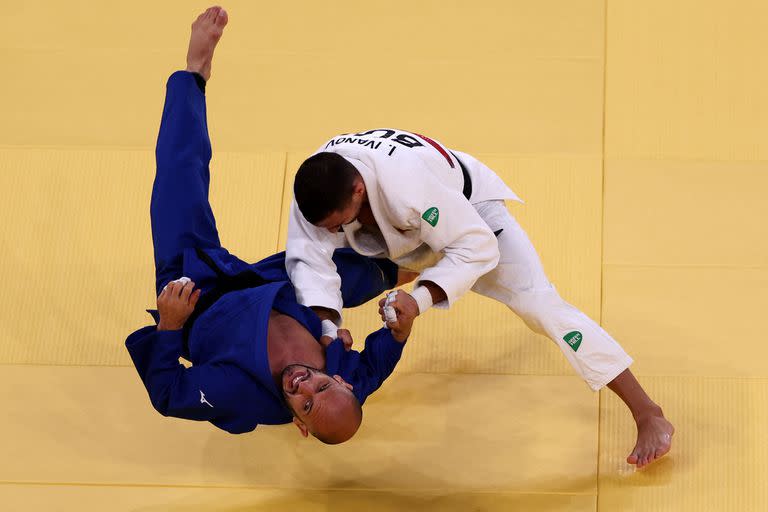 El búlgaro Ivaylo Ivanov (blanco) y el argentino Emmanuel Lucenti compiten en la ronda eliminatoria masculina de judo de -81 kg durante los Juegos Olímpicos de Tokio 2020 en el Nippon Budokan en Tokio el 27 de julio de 2021