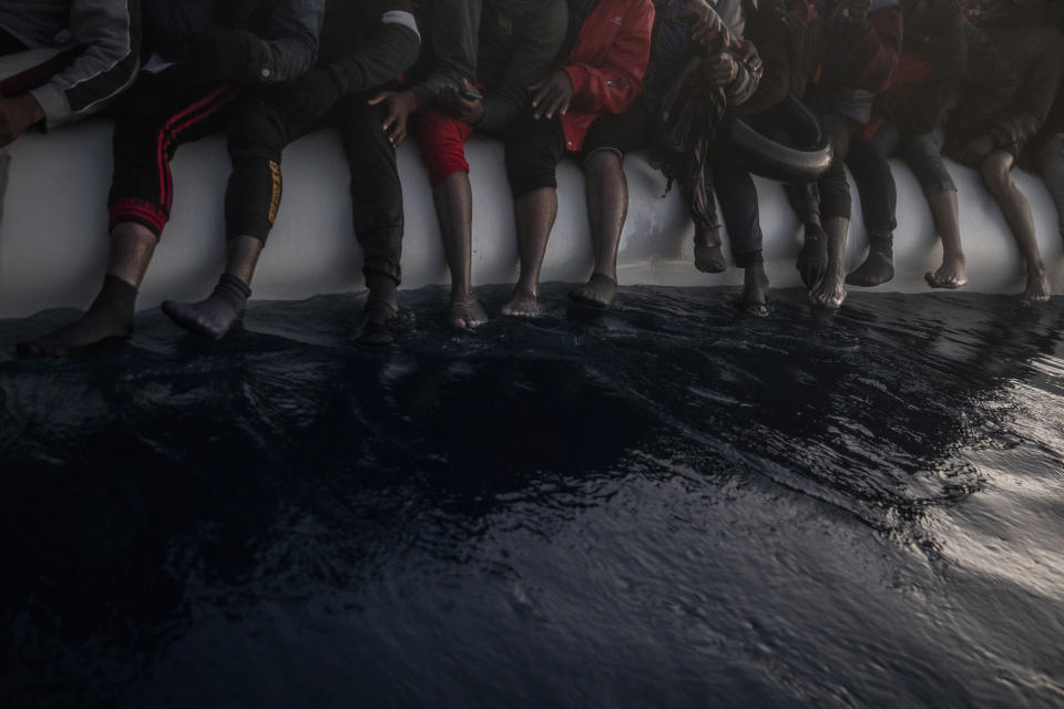 FILE - In this Saturday, Feb. 13, 2021 file photo, migrants and refugees from different African nationalities are seen barefoot on an overcrowded rubber boat as they wait for assistance as aid workers of the Spanish NGO Open Arms rescue vessel approaches them in the Mediterranean Sea, international waters, at 80 miles off the Libyan coast. The U.N. migration agency says the number of migrants and refugees who died while attempting to reach Europe on dangerous sea routes more than doubled so far this year compared to the first six months of 2020. The International Organization for Migration said in a new report Wednesday, July 14, 2021 that at least 1,146 people perished between January and June. (AP Photo/Bruno Thevenin, File)