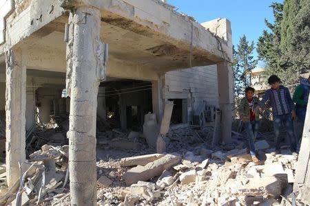 People inspect a damaged site after an airstrike on rebel-held Urum al-Kubra town in Aleppo province, Syria November 2, 2016. REUTERS/Ammar Abdullah