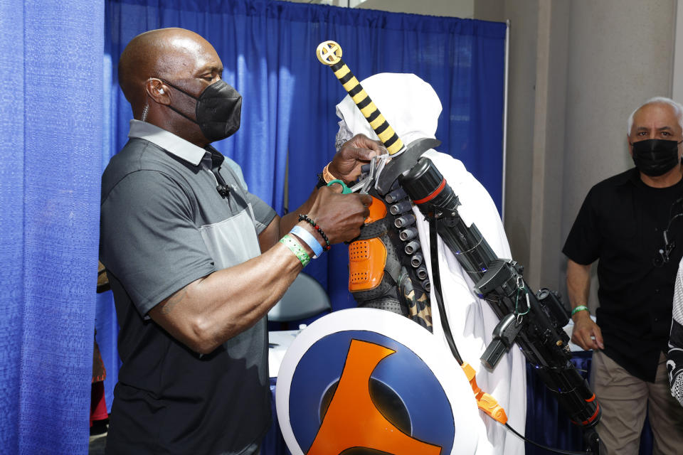 A member of event security tags a costume prop weapon worn by a cosplayer on day two on day two of Comic-Con International on Friday, July 22, 2022, in San Diego. (Photo by Christy Radecic/Invision/AP)