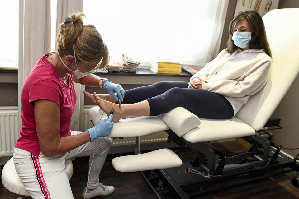 A patient attends a physiotherapist session, on 30 April 2020, in Antwerp, northern Belgium. - The government has announced a phased plan to ease the lockdown in the country as Belgium is in its seventh week of lockdown in the ongoing COVID-19 pandemic, caused by the novel coronavirus. (Photo by DIRK WAEM / BELGA / AFP) / Belgium OUT (Photo by DIRK WAEM/BELGA/AFP via Getty Images)