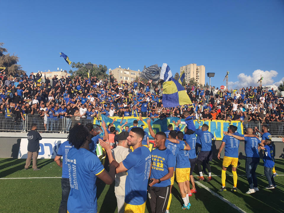 Una imagen proporcionada por el Maccabi Bnei Reineh muestra a los futbolistas e hinchas celebrando el ascenso a la primera división de Israel el mes pasado. (Maccabi Bnei Reineh vía The New York Times)
