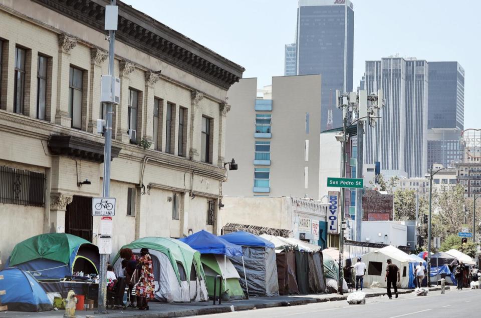 IMAGE: People walk near a homeless encampment in the Skid Row neighborhood on July 25, 2024 in Los Angeles. (Mario Tama/Getty Images)