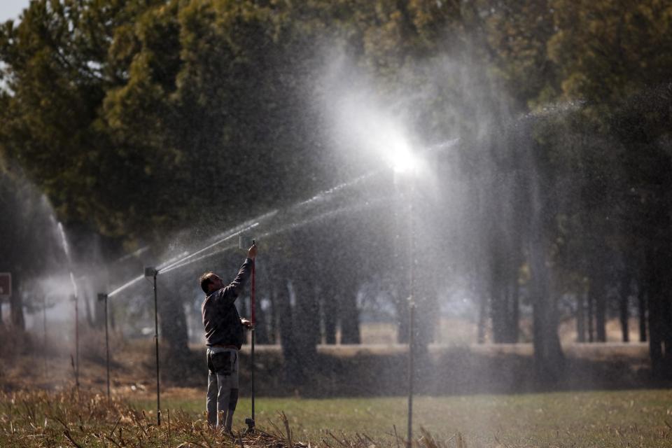 Farmer Jose Manuel Allue controls his irrigation sprayers as he waters his crop in Robres village, Huesca, Spain, Tuesday March 13, 2012. Spain is suffering the driest winter in more than 70 years, adding yet another woe for an economically distressed country that can scarcely afford it. Thousands of jobs and many millions of euros could be in jeopardy. (AP Photo/Emilio Morenatti)