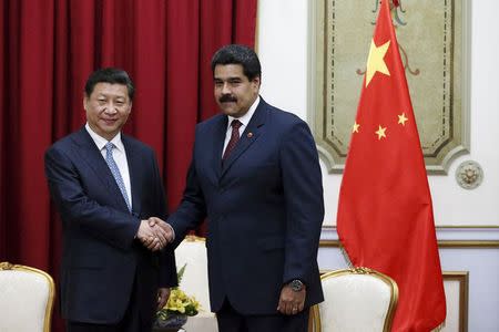 China's President Xi Jinping (L) shakes hands with Venezuela's President Nicolas Maduro at a meeting in Miraflores Palace in Caracas July 20, 2014. REUTERS/Jorge Silva/Files