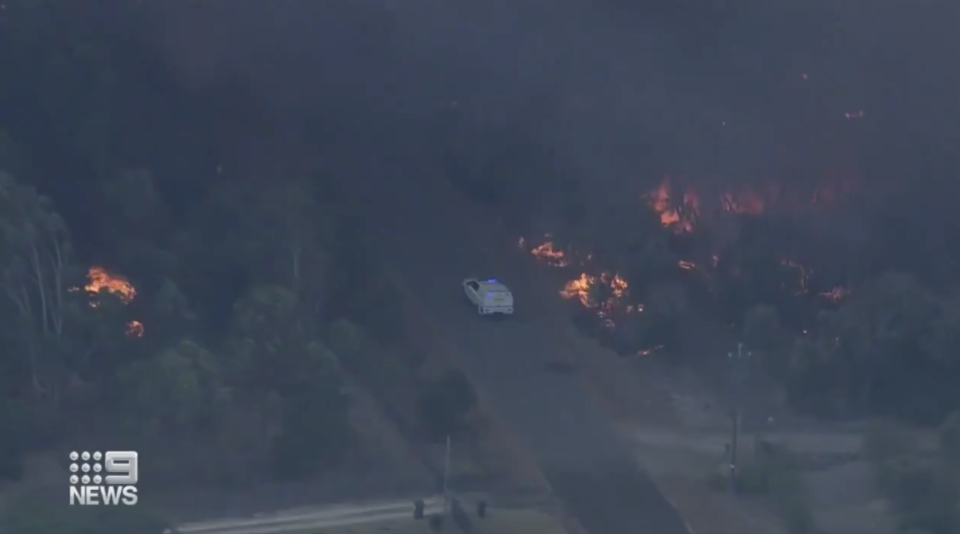 A police car travels through bushfires south of Perth.