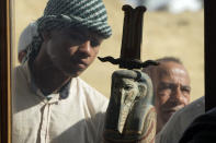 An Egyptian antiquities worker watches a recently discovered artifact at the site of the Step Pyramid of Djoser in Saqqara, 24 kilometers (15 miles) southwest of Cairo, Egypt, Thursday, Jan. 26, 2023. Egyptian archaeologist Zahi Hawass, the director of the Egyptian excavation team, announced that the expedition found a group of Old Kingdom tombs dating to the fifth and sixth dynasties of the Old Kingdom, indicating that the site comprised a large cemetery. (AP Photo/Amr Nabil)