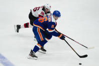 New Jersey Devils' Jack Hughes (86) defends against New York Islanders' Oliver Wahlstrom (26) during the third period of an NHL hockey game Thursday, May 6, 2021, in Uniondale, N.Y. The Devils won 2-1. (AP Photo/Frank Franklin II)