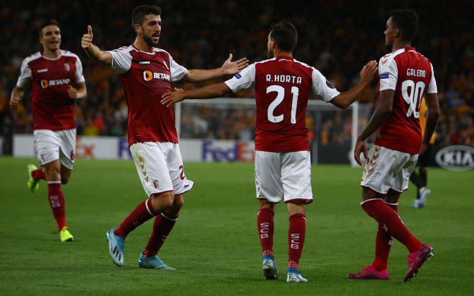 Ricardo Horta is mobbed by his team-mates after scoring the second-half winner at Molineux - AFP or licensors