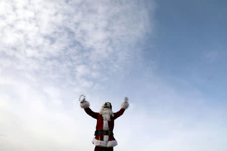 Israeli-Arab Issa Kassissieh wears a Santa Claus costume during the annual Christmas tree distribution by the Jerusalem municipality in Jerusalem's Old City December 21, 2017. REUTERS/Ammar Awad