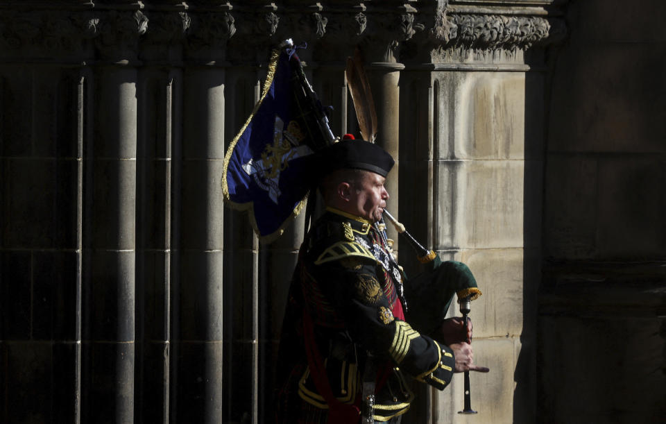 A piper plays outside St. Giles Cathedral, in Edinburgh, Scotland, Tuesday, Sept. 13, 2022. King Charles III and Camilla, the Queen Consort, flew to Belfast from Edinburgh on Tuesday, the same day the queen’s coffin will be flown to London from Scotland. (Kai Pfaffenbach/Pool Photo via AP)