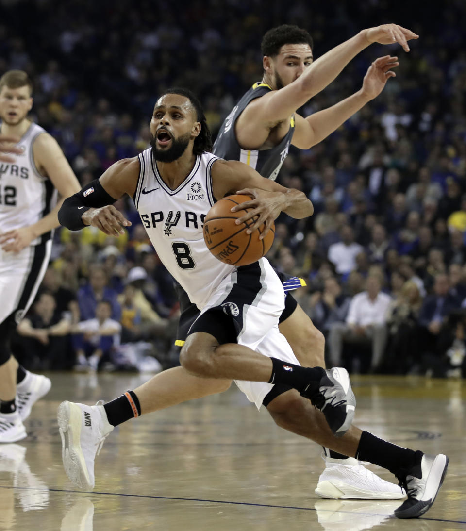 San Antonio Spurs' Patty Mills (8) drives the ball past Golden State Warriors' Klay Thompson during the first half of an NBA basketball game Wednesday, Feb. 6, 2019, in Oakland, Calif. (AP Photo/Ben Margot)