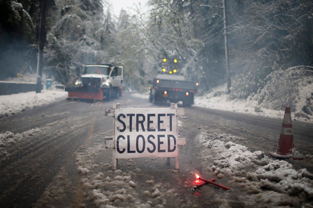 Crews closed W Burnside Rd. at SW Tichner Dr. as several inches of snow fell in the Portland area on, Monday, April 11, 2022. Portland received the first measurable snowfall in April in recorded history on Monday. (Dave Killen/The Oregonian via AP) (AP)