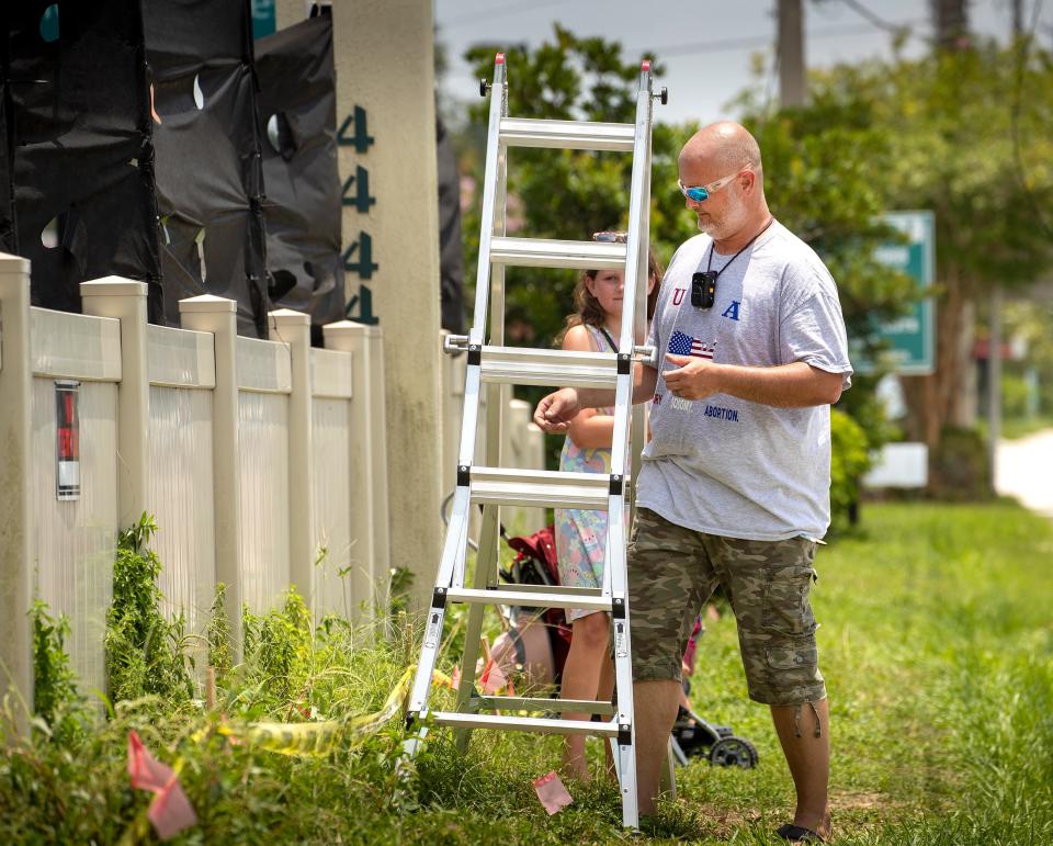 Greg Delauny packs up his extension ladder after Lakeland police arrested his wife, Angela, while protesting outside the Lakeland Women's Health Center on South Florida Avenue.