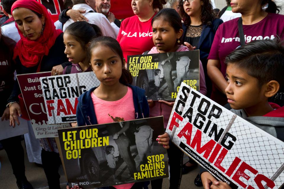 FILE - In this June 26, 2018, file photo, children stand and hold protest signs during a rally in front of Federal Courthouse in Los Angeles. A panel of appeals court judges in California will hear arguments in the long-running battle between advocates for immigrant children and the U.S. government over conditions in detention and holding facilities near the southwest border. (AP Photo/Richard Vogel, File)