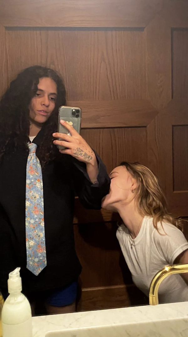 lily biting 070 shake's arm while they take a mirror selfie