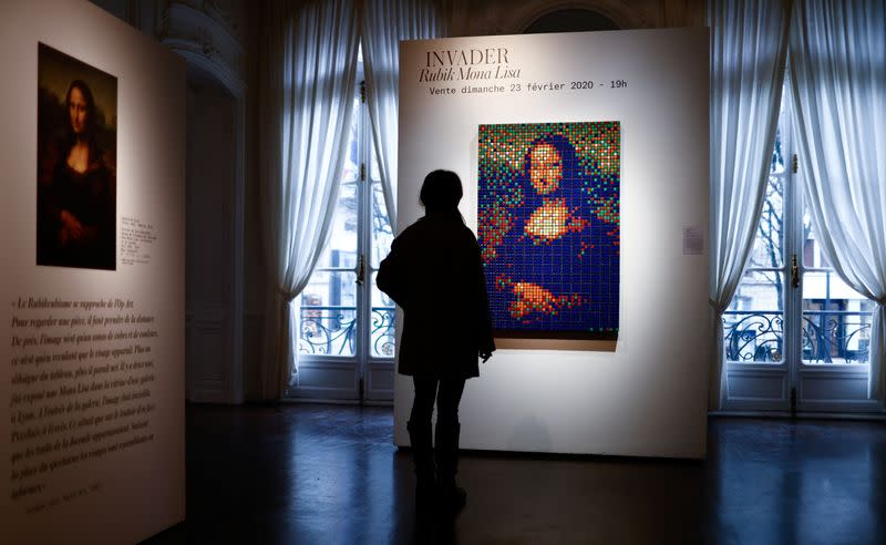 A woman looks a the Rubik Mona Lisa (2005) by French street artist Invader is displayed at ArtCurial in Paris