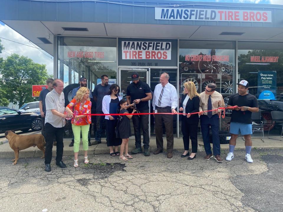 Kenzy Fares, 7, the daughter of Fares Fares, the owner of Mansfield Tire Bros, 395 Park Avenue West, helps cuts the ribbon at the grand opening celebration. Richland Area Chamber & Economic Development members and public officials joined for the cookout and ceremony.