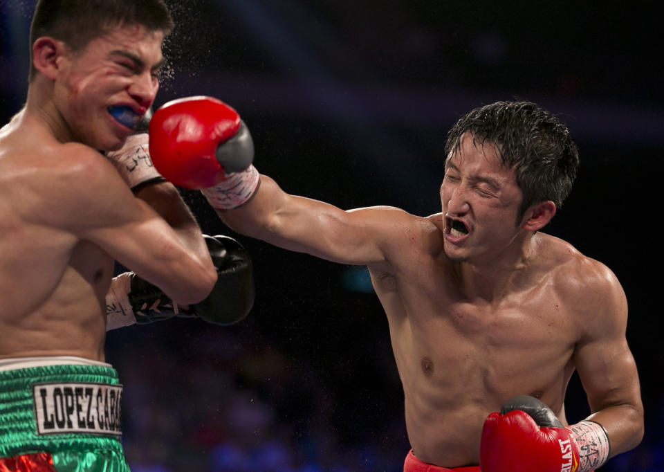 In this July 27, 2013 photo, China's Zou Shiming, right, fights against Mexico's Jesus Ortega during their Flyweight bout at the Cotai Arena in Venetian Macao in Macau. The Chinese fighter’s victory at a Macau showdown brings the world’s top casino market a step closer to challenging Las Vegas for dominance of another Sin City staple: big-time boxing matches. Macau, which long ago eclipsed Vegas as the world's top gambling city, is now looking to add to its allure by holding the kind of boxing bouts that Las Vegas is known for. (AP Photo/Dennis Ho)