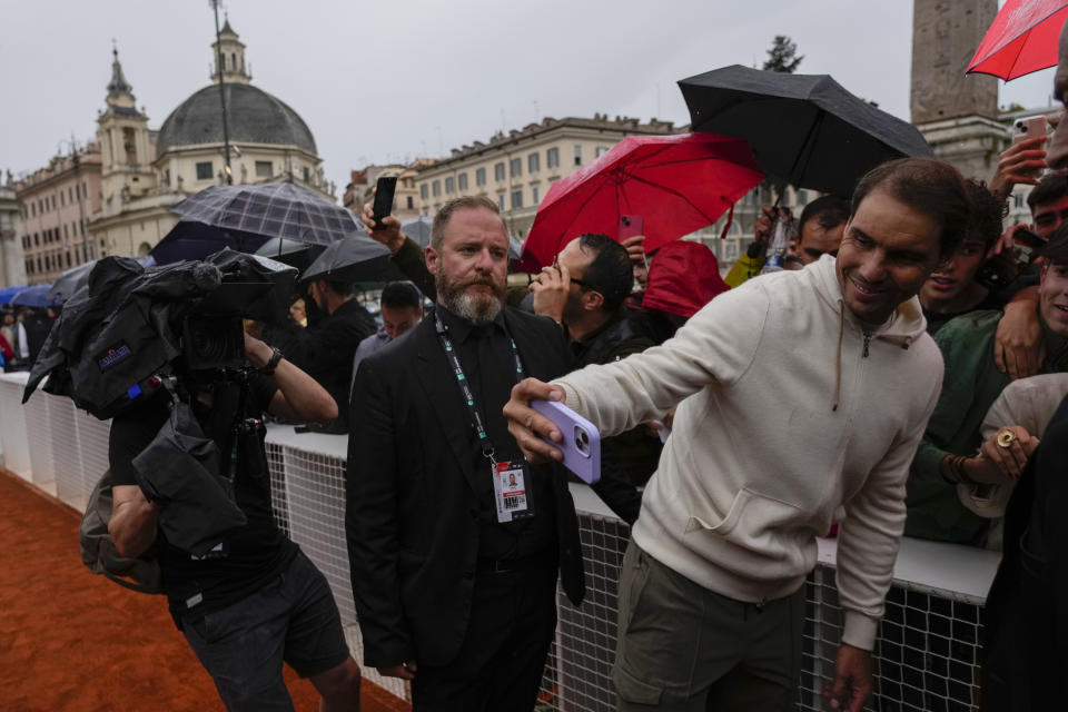 Rafael Nadal takes selfies with supporters during an event at Rome's Piazza Del Popolo, Wednesday, May 8, 2024. The 37-year-old Nadal, who has indicated that this will be his final year on tour, has played only nine matches this year after missing nearly all of 2023 due to a hip injury that required surgery. (AP Photo/Alessandra Tarantino)