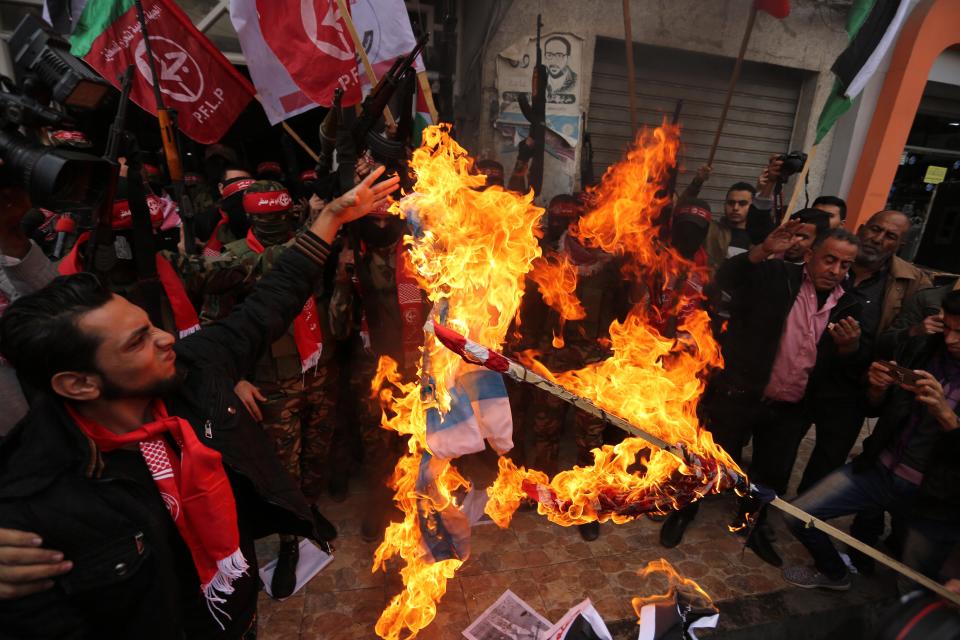 <p>Palestinian militants of the Popular Front for the Liberation of Palestine (PFLP) burn an Israeli flag and a U.S. flag during a protest against following Trump’s decision to recognize Jerusalem as the capital of Israel, in Gaza City, Dec. 7, 2017. (Photo: APAImages/REX/Shutterstock) </p>