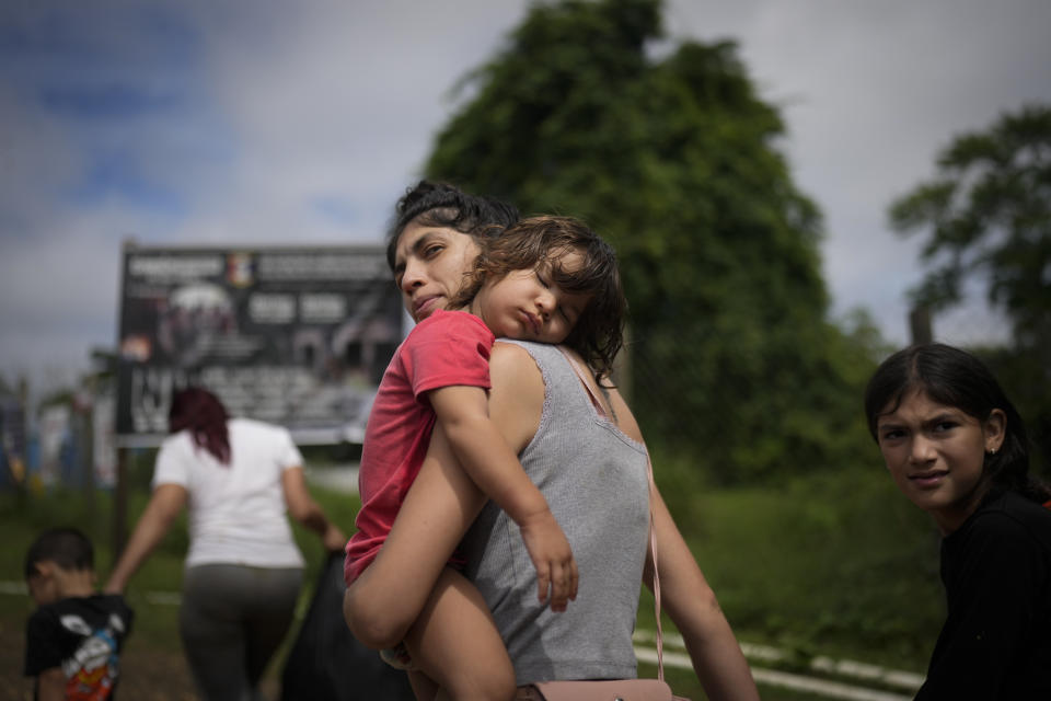 Venezuela migrant Naiber Zerpa holds her son Mathias Marquez as they arrive at a temporary camp after walking across the Darien Gap from Colombia, in Lajas Blancas, Panama, Friday, June 28, 2024. (AP Photo/Matias Delacroix)