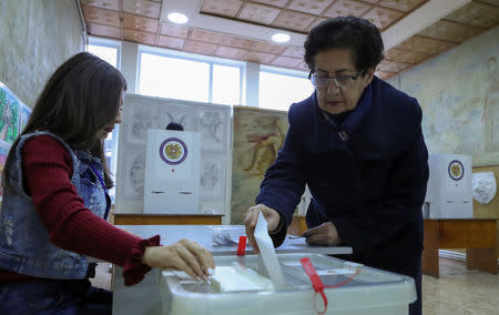 A woman casts her ballot during an early parliamentary election in the town of Vagharshapat, Armenia December 9, 2018. REUTERS/Vahram Baghdasaryan/Photolure