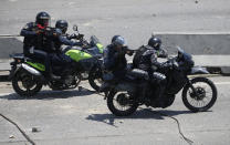 FILE - In this April 30, 2019 file photo, police aim weapons at opponents to Venezuela's President Nicolas Maduro during clashes in Caracas, Venezuela, hours after opposition leader Juan Guaidó took to the streets in a bold and risky attempt to lead a military uprising against the president. Last April, as a military uprising roiled Venezuela, Maduro’s socialist government ordered pay TV providers to immediately cease transmission of CNN and the BBC. DirecTV, which is wholly owned by AT&T, quickly obliged, yanking the two networks off the air. (AP Photo/Fernando Llano, File)