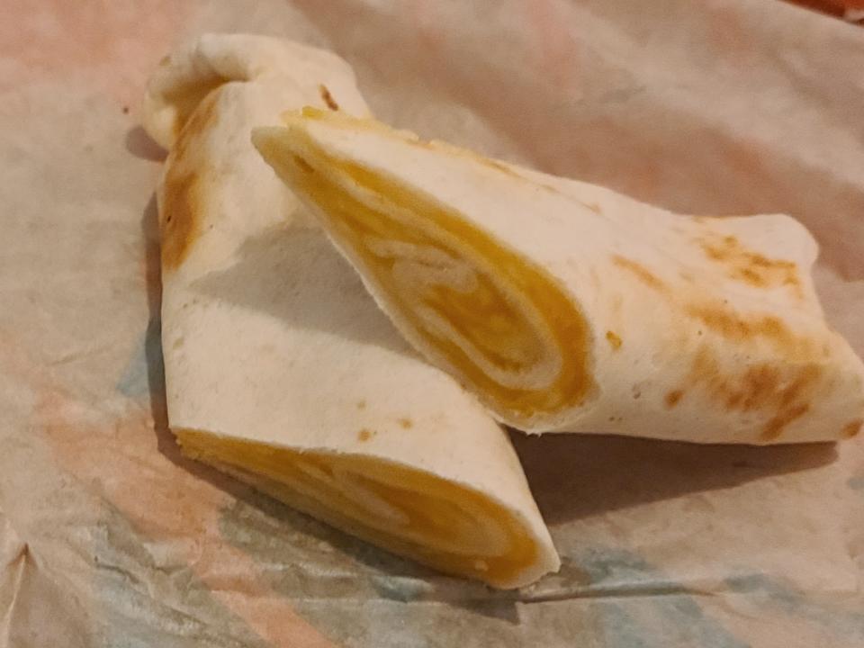 cheesy roll up from taco bell resting on its wrapper