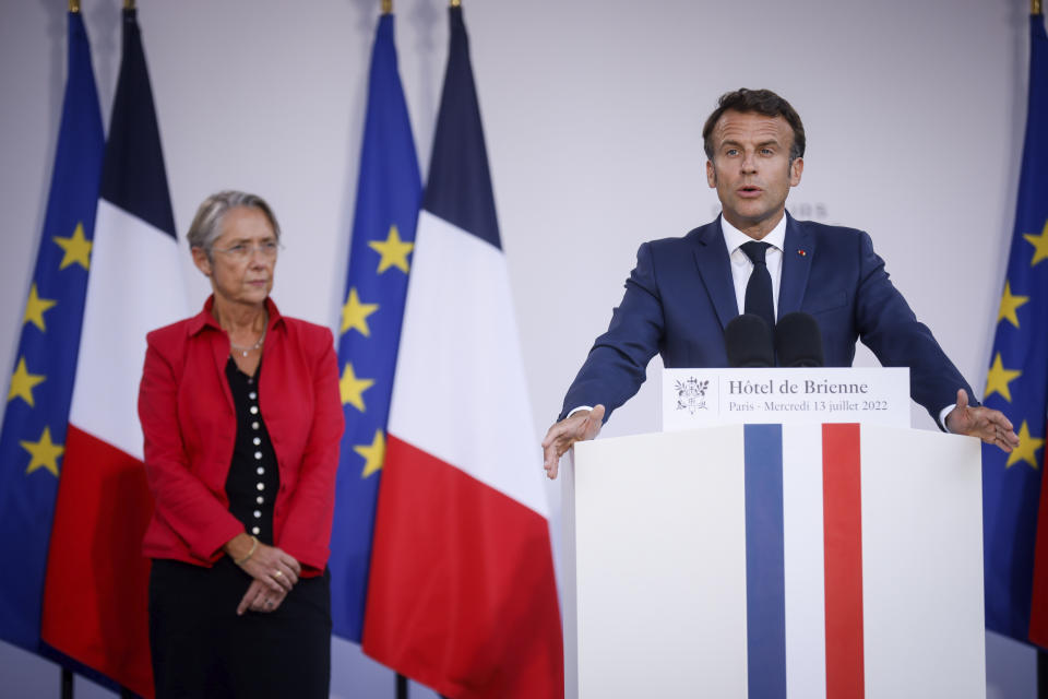 French President Emmanuel Macron delivers his speech to militaries while Prime Minister Elisabeth Borne listens, on the eve of Bastille Day, Wednesday, July 13, 2022 at the Defense Minister's residence in Paris. France will celebrates its national holidays Thursday with thousands of French and allies from Eastern Europe troops surrounded by planes, vehicles, and a drone, to highlight France's military efforts to support Ukraine. (AP Photo/Thomas Padilla, Pool)