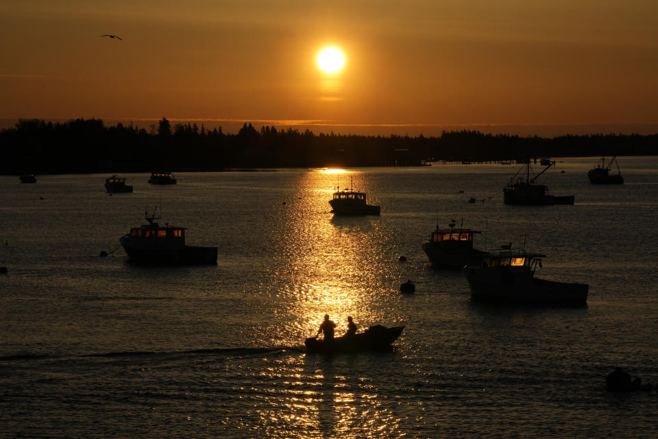 Lobstermen motor out to their moored fishing boat in Jonesport, Maine, Thursday, April 28, 2023. The fishing industry is a major employer in the rural area where a local family wants to build the world's tallest flagpole. Situated at the nation’s eastern tip, Maine’s Down East region is the place where the sunlight first kisses U.S. soil each day. (AP Photo/Robert F. Bukaty)