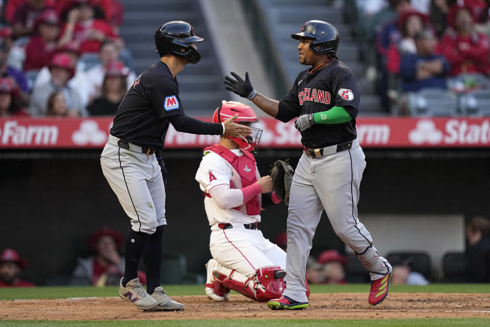 Cleveland Guardians' Jose Ramirez, right, is congratulated by Andres Gimenez after hitting a two-run home run as Los Angeles Angels catcher Logan O'Hoppe kneels at the plate during the third inning of a baseball game Friday, May 24, 2024, in Anaheim, Calif. (AP Photo/Mark J. Terrill)