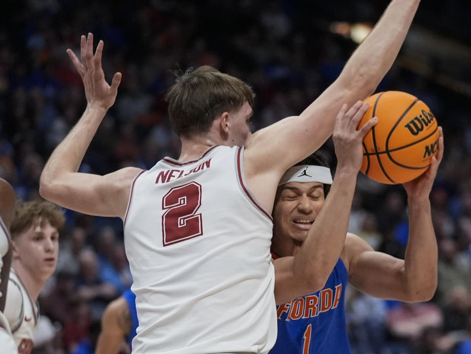 Florida guard Walter Clayton Jr. (1) tries to work inder Alabama forward Grant Nelson (2) during the second half of an NCAA college basketball game at the Southeastern Conference tournament Friday, March 15, 2024, in Nashville, Tenn. (AP Photo/John Bazemore)