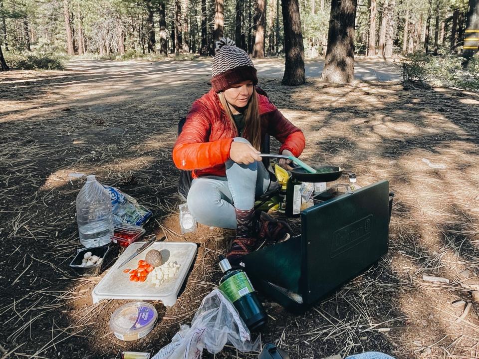 Nicole Jordan cooking a dinner with a portable stove in the forest