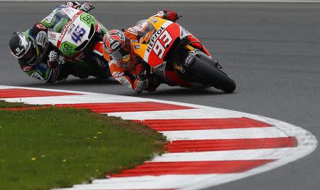 Honda MotoGP rider Marc Marquez (R) of Spain competes with Honda MotoGP rider Scott Redding of Britain during the qualifying session for the British Grand Prix at the Silverstone Race Circuit, central England, August 30, 2014. REUTERS/Darren Staples