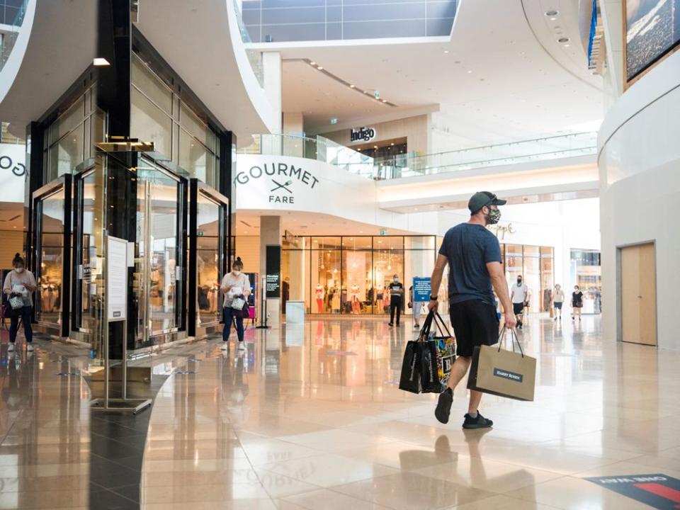 FILE PHOTO: A shopper exits a store holding multiple shopping bags in Sherway Gardens mall during the stage two reopening from coronavirus disease (COVID-19) restrictions in Toronto, Ontario, Canada June 30, 2021.