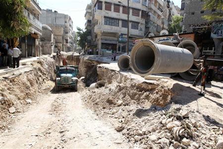 Workers install pipes along a street in Aleppo September 9, 2013. REUTERS/Muzaffar Salman