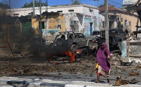 A Somali woman walks past the scene of an explosion near Waberi police station station in Mogadishu, Somalia June 22, 2017. REUTERS/Feisal Omar