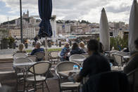 People enjoy refreshments at a restaurant, in Marseille, southern France, Sunday Sept. 27, 2020. As restaurants and bars in Marseille prepared Sunday to shut down for a week as part of scattered new French virus restrictions, Health Minister Olivier Veran insisted that the country plans no fresh lockdowns. (AP Photo/Daniel Cole)