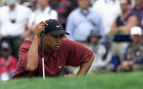 Tiger Woods lines up a putt on the first green during the final round of the 100th US Open - Credit: Getty Images