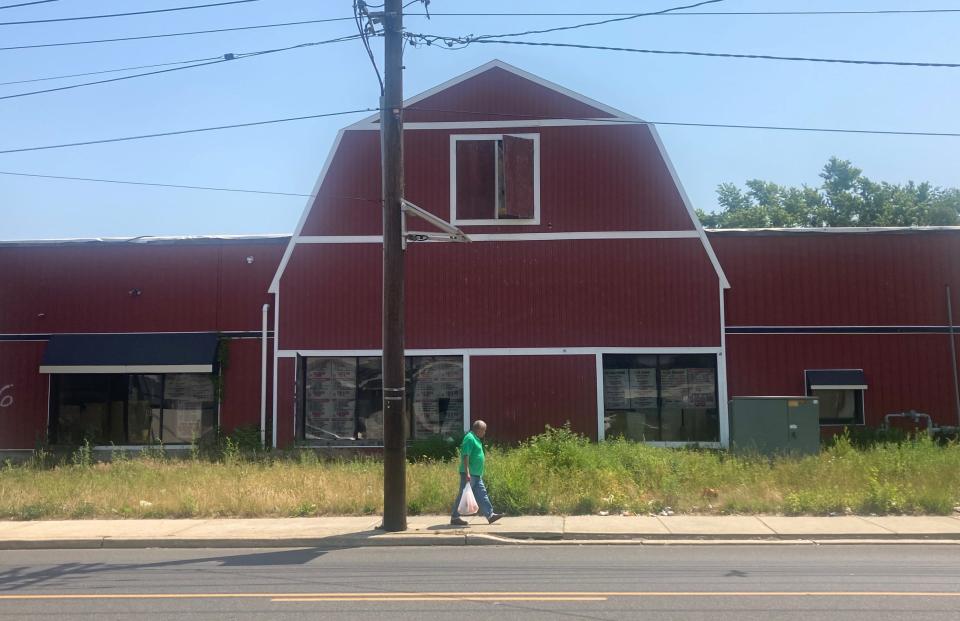 A man walks past the former Haddon Meat Market, which is the site of a planned warehouse on the 2800 block of Mount Ephraim Avenue in Camden.