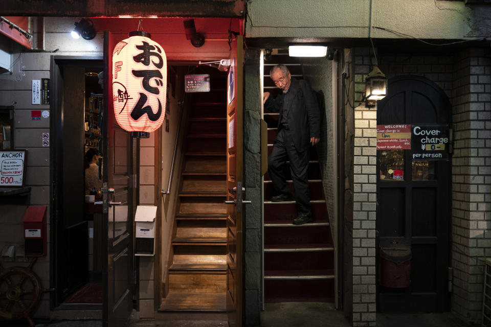 A man walks down the steps of a bar at the Golden Gai in the Shinjuku district of Tokyo, July 17, 2019. (AP Photo/Jae C. Hong)