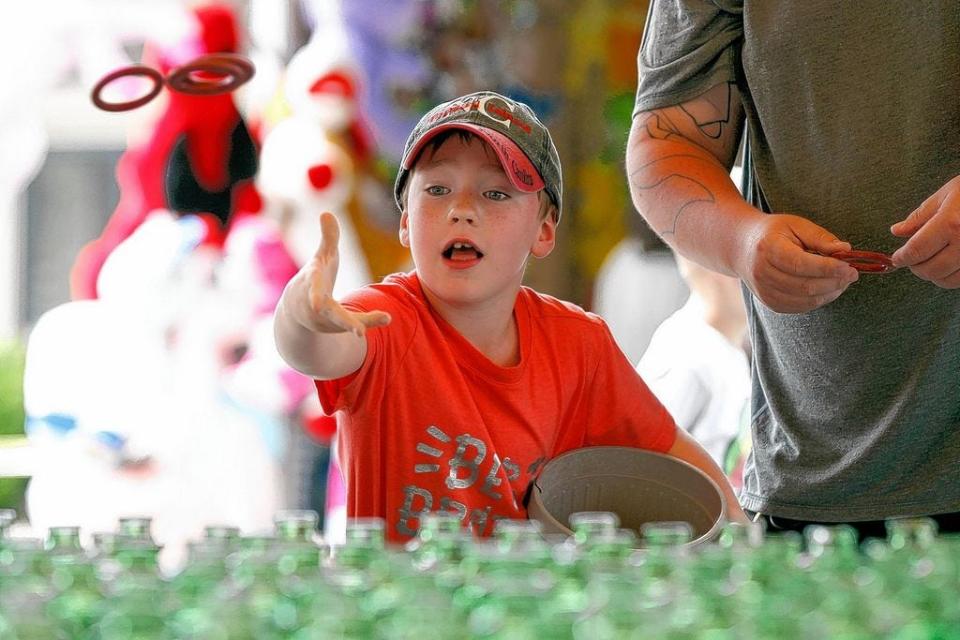 Ryker Lucas, then 7, of Grove City tosses several rings out in hopes of winning a prize at an amusement game during the 99th annual Canal Winchester Labor Day Festival last year in the historic downtown area. This year's festival, which would have been the centennial, has been canceled due the COVID-19 coronavirus pandemic.