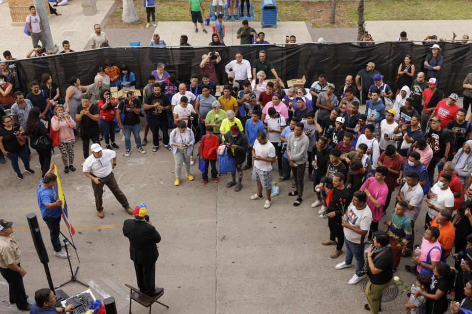 A local church pastor, Rev. Carlos Navarro, speaks to migrants and community members at a vigil for the eight migrants that were killed and several others that were injured the day before while waiting at a bus stop, in Brownsville, Texas, Monday, May 8, 2023. (AP Photo/Michael Gonzalez)