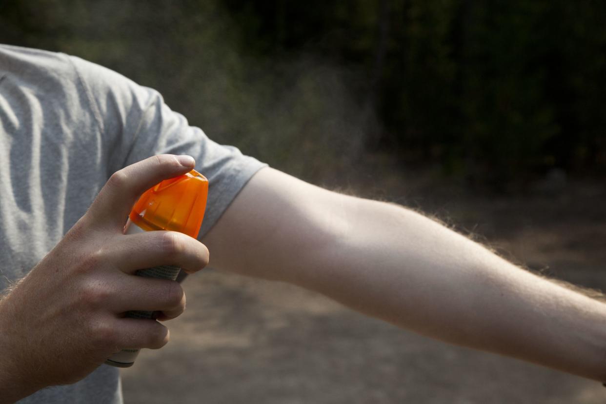 A man is trying to protect himself from insects.