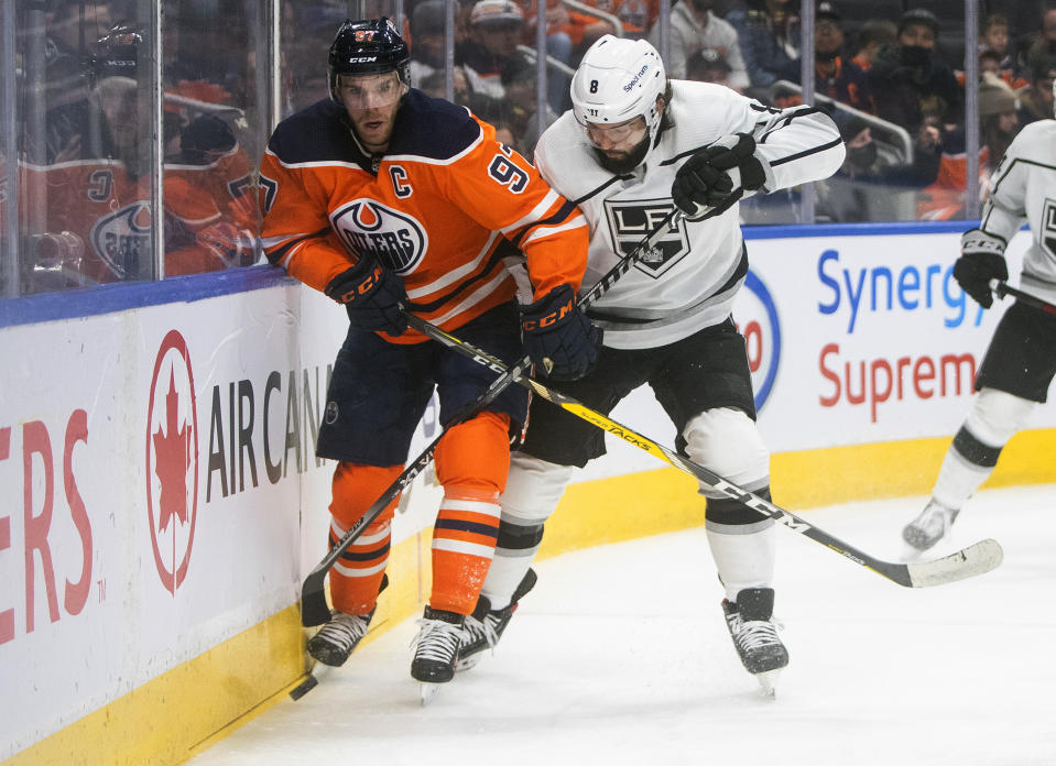 Los Angeles Kings' Drew Doughty (8) and Edmonton Oilers' Connor McDavid (97) battle for the puck during the second period of an NHL hockey game in Edmonton, Alberta, Sunday, Dec. 5, 2021. (Jason Franson/The Canadian Press via AP)