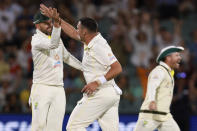 Australia's Scott Boland, center, celebrates with teammate Nathan Lyon after taking the wicket of the West Indies Jermaine Blackwood on the third day of their cricket test match in Adelaide, Saturday, Nov. 10, 2022. (AP Photo/James Elsby)