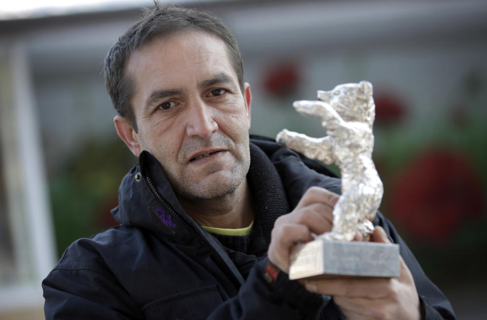 In this photo taken Saturday, Jan. 25, 2014, Bosnian actor Nazif Mujic holds his Silver Bear Best Actor award for his role in 'An Episode In the Life of an Iron Picker' prior to an interview with the Associated Press in Berlin, Germany. Mujic, a Roma from a tiny village in Bosnia, won the Silver Bear award in 2013. Now, almost a year later, the movie star has turned into an asylum seeker. Mujic is back in Berlin, but this time he came with his family to apply for asylum, was rejected by the German authorities and is desperately fighting his deportation back to Bosnia in March. (AP Photo/Michael Sohn)